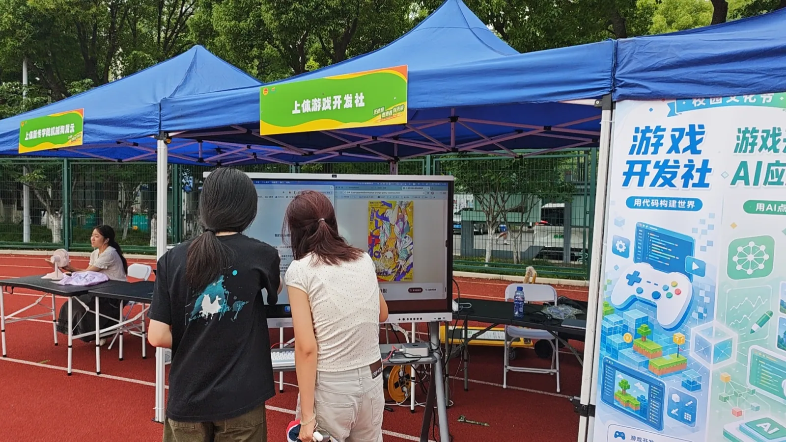 5 月 27 日，同学们在校园文化节摊位观看屏幕演示